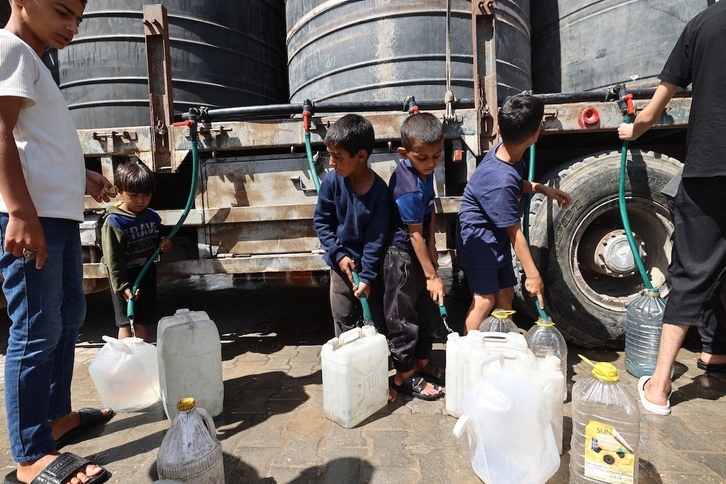 Niños palestinos en busca de agua potable en el campo de refugiados de ​​Nuseirat.