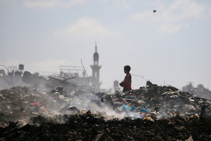 Un niño palestino busca entre la basura en el campo de refugiados de Bureij, en el centro de Gaza.