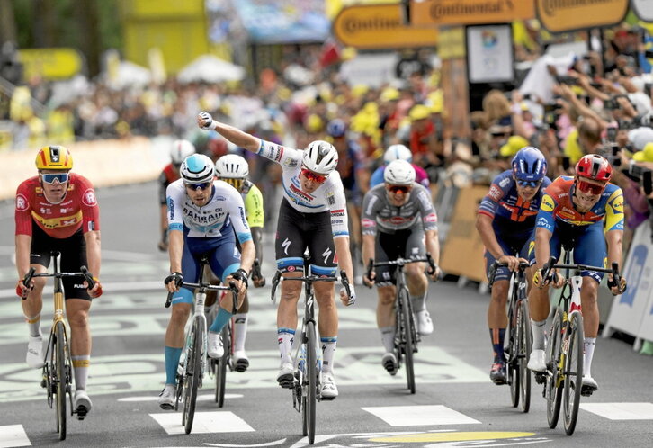 Tim Merlier alza el brazo tras ganar por milímetros en Dunkerque.