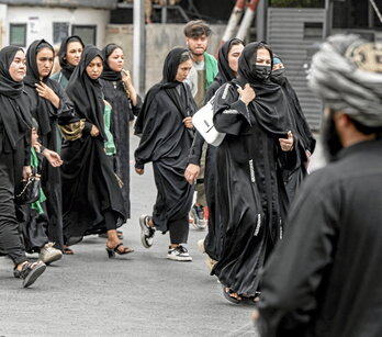 Mujeres afganas chiíes asisten a la Ashura ante la mirada de un talibán.