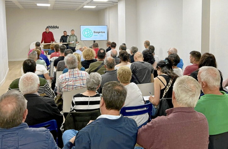 Goian, Urbiako haize-errotak. Behean, Mikel Otero, erdian, Bizigintza ponentziaren aurkezpen batean.