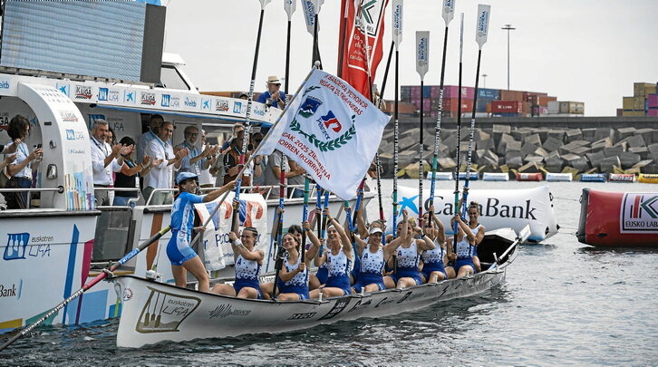 Joana Halsouet Arraun Lagunak-eko patroia, poz-pozik, Petronor bandera astintzen.