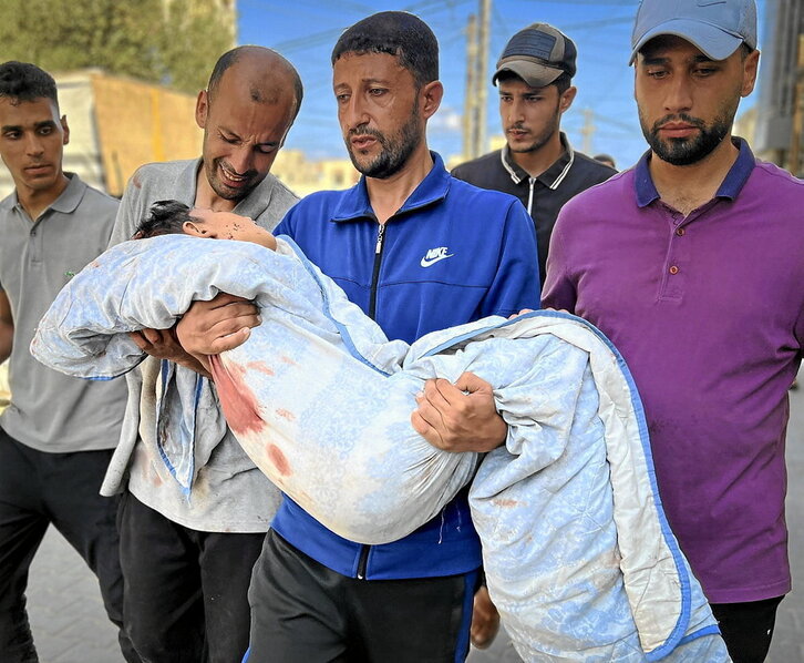 Palestinos llevan el cuerpo de una víctima del ataque de Nuseierat.