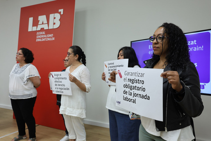 Trabajadoras del hogar muestran carteles con algunas de sus reivindicaciones básicas.