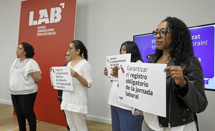 Trabajadoras del hogar muestran carteles con algunas de sus reivindicaciones.