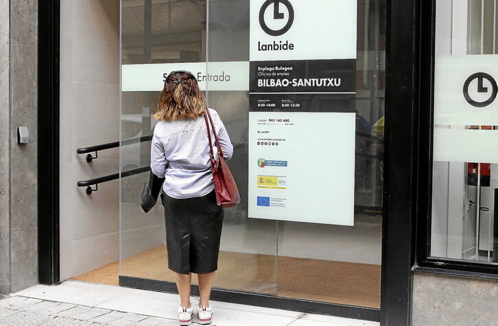 Una mujer se dispone a entrar en una oficina de Lanbide.