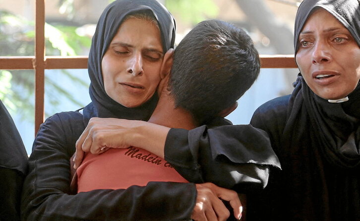 Una mujer abraza a un niño tras identificar a un familiar entre los palestinos muertos en ataques israelíes contra Al-Mawasi y Jan Yunis.