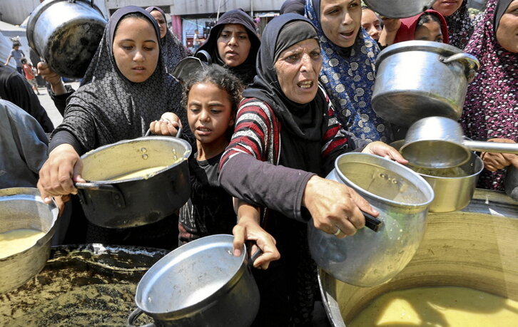 Un niño palestino, junto a una olla de sopa.
