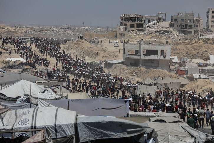 Palestinos cargan sacos de harina recogidos en el reparto de un convoy en Yabalia.