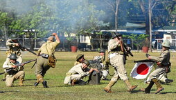 A la izquierda, una mujer observa la Cúpula de la Bomba Atómica, en el centro de Hiroshima. Abajo,  recreación de la batalla de Manila a cargo de la Sociedad de Historia Viva.