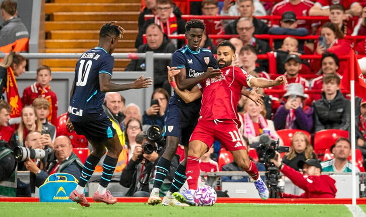 Adama Boiro intenta frenar a Mohamed Salah ante la presencia de Nico Williams en el partido nocturno de Anfield.