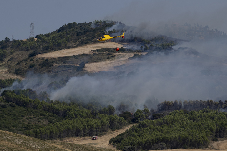 Un helicóptero sobrevuela Obanos y Muruzabal en el incendio desatado el martes.