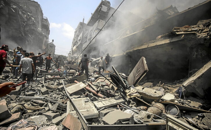 Residentes enCiudad de Gaza observan la masiva destrucción causada por uno de los bombardeos.