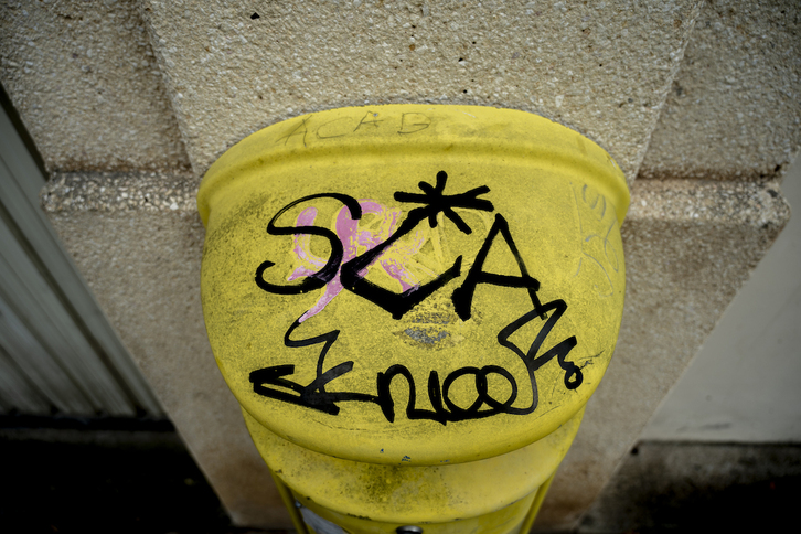 Pintada de ‘ACAB’ en el contenedor de pilas que generó lo de la Ertzaintza define como «graves incidentes».