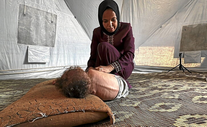 El niño Adham Abu Armanah, que sufre malnutrición severa, atendido por su madre en Nuseierat.