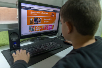 Un joven mira ofertas de Black Friday en un ordenador.