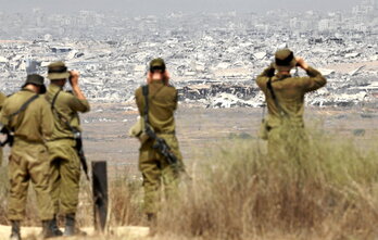 Soldados israelíes observan los edificios destruidos de Gaza.