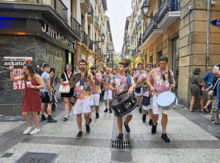 La txaranga Pasai en dos momentos de su actuación: arriba, por la Parte Vieja; abajo, entre las terrazas de Reyes Católicos.