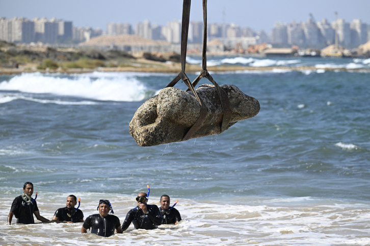 Una grúa saca del agua una estatua, en la bahía de Alejandría.