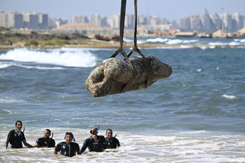 Una grúa saca del agua una estatua, en la bahía de Alejandría.