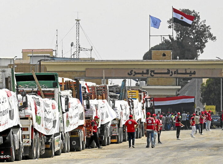 Camiones cargados con ayuda esperan en el lado egipcio del cruce de Rafah.
