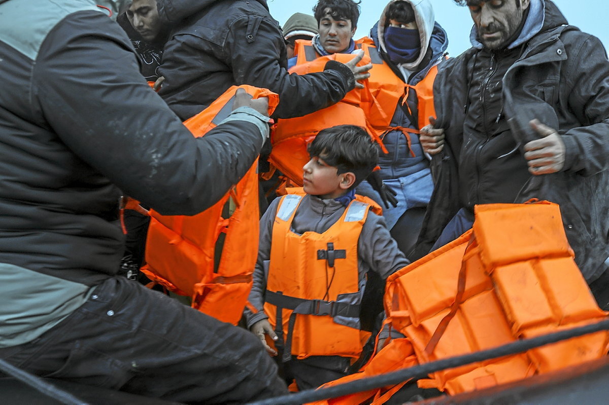 Migrantes procedentes de Kurdistán se colocan los chalecos salvavidas antes de salir hacia Gran Bretaña. (Sergi Cámara)