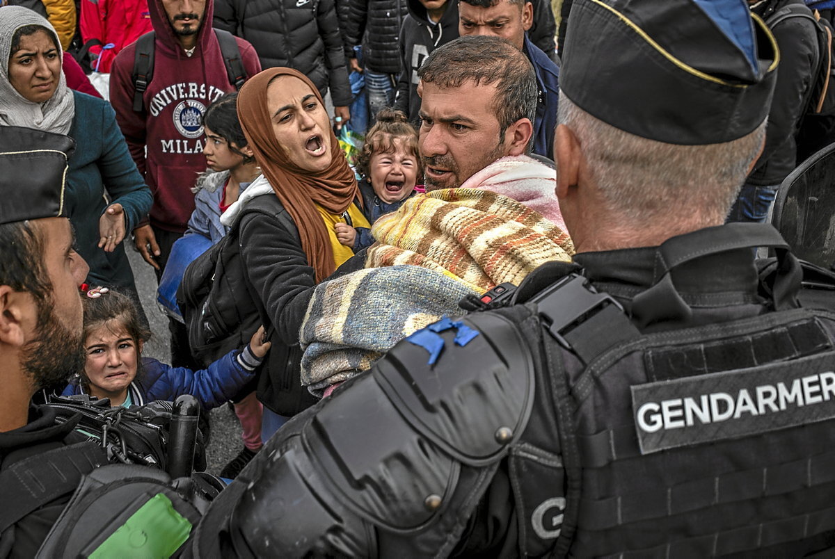 Una familia intenta escapar del cordón policial que quiere desalojar el campamento de Loon-Plage. (Sergi Cámara)