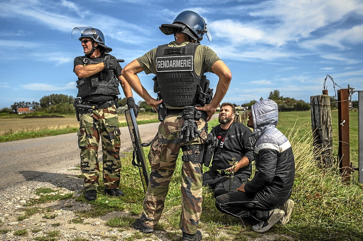 Policías antidisturbios detienen a varias personas que intentaban partir hacia Gran Bretaña en Oye-Plage. (Sergi Cámara)