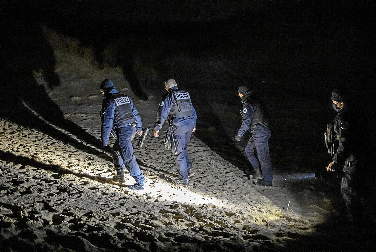 Agentes patrullando de noche por las dunas en busca de migrantes que intentan cruzar. (Sergi Cámara)