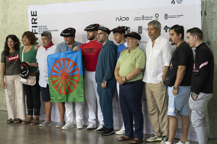 Familiares, pelotaris y organizadores del homenaje posando con la bandera del pueblo gitano