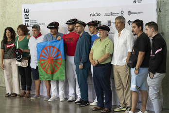 Familiares, pelotaris y organizadores del homenaje posando con la bandera del pueblo gitano