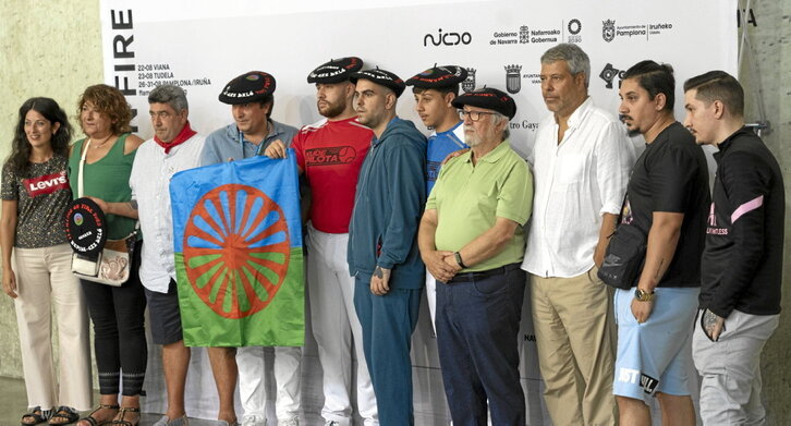 Familiares, pelotaris y organizadores del homenaje posando con la bandera del pueblo gitano.