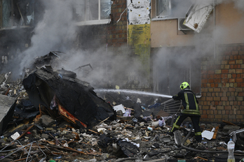 Bomberos apagan el fuego provocado por el ataque ruso sobre Kiev, realizado de madrugada.