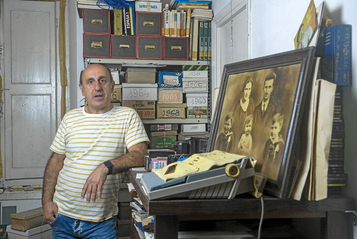 Rikardo Intxausti, bere aita Germanen artxiboan. Atzeko aldean, kartoizko kutxetan, irudiak daude urteko antolatuta.