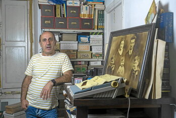 Rikardo Intxausti, bere aita Germanen artxiboan. Atzeko aldean, kartoizko kutxetan, irudiak daude urteko antolatuta.