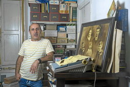 Rikardo Intxausti, bere aita Germanen artxiboan. Atzeko aldean, kartoizko kutxetan, irudiak daude urteko antolatuta.