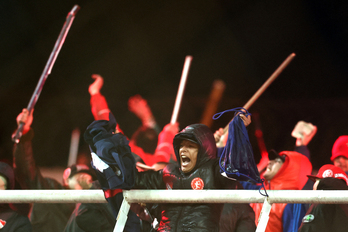 Hinchas de Independiente agitan palos en las gradas  durante la interrupción del partido de vuelta de los octavos de final de la Copa Sudamericana entre Independiente de Argentina y Universidad de Chile. 