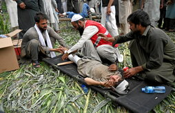 Un niño recibe atención en una camilla junto a edificios dañados en la aldea de Mazar Dara, en Nurgal, provincia de Kunar.