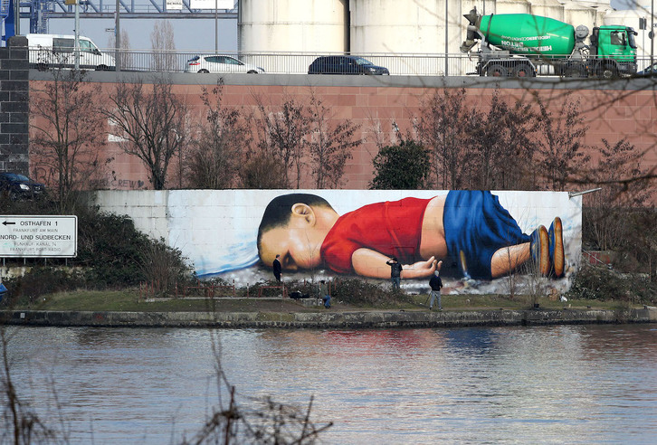 Mural que recrea la fotografía del niño Alan Kurdi en el puerto de Frankfurt.