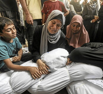 Varias personas lloran a sus familiares muertos en un ataque israelíe.