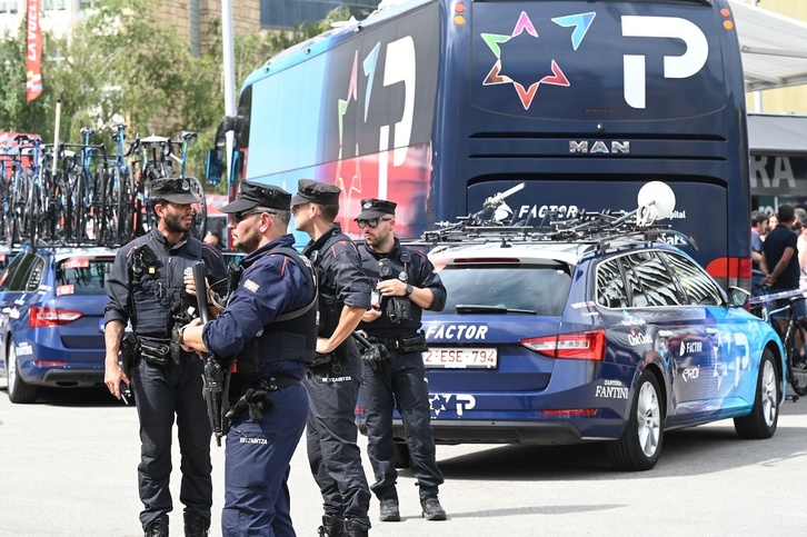 Ertzainas protegen el autobús y un coche del equipo Israel-Premier Tech el miércoles en Bilbo.