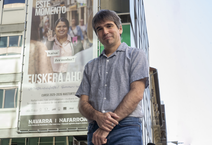 Jabier Arakama posa ante la sede de Euskarabidea, donde se ha desplegado una gran lona que fomenta la euskaldunización de adultos.
