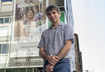 Jabier Arakama posa ante la sede de Euskarabidea, donde se ha desplegado una gran lona que fomenta la euskaldunización del adultos.