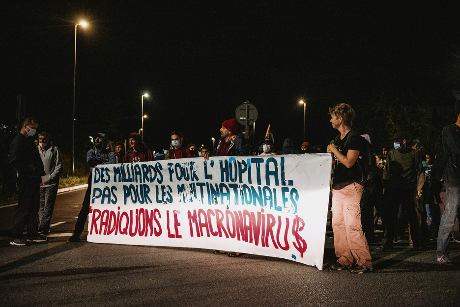 Multinazionalek eta aberatsek jasotzen dituzten mozkinak erietxeetara bideratzeko aldarrikapena hedatu dute, banderola bat biribilgunean zabalduz.