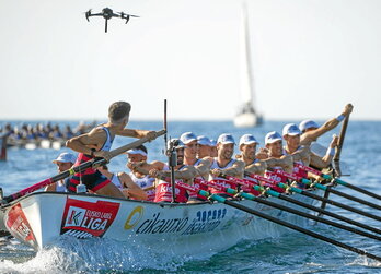 Argazki nagusian, ETBko dronea Ondarroako traineruaren gainean. Lerro hauen gainean, traineruan joaten den minikamera bat.