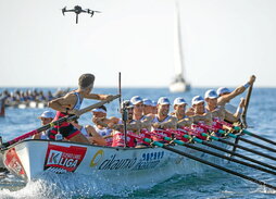 Argazki nagusian, ETBko dronea Ondarroako traineruaren gainean. Lerro hauen gainean, traineruan joaten den minikamera bat.