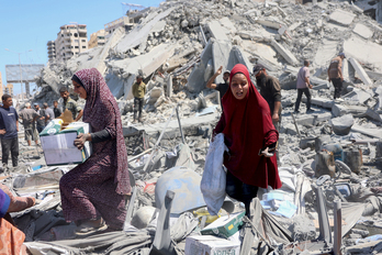 Habitantes de Ciudad de Gaza buscan sus pertenencias entre las ruinas de edificios demolidos por Israel.
