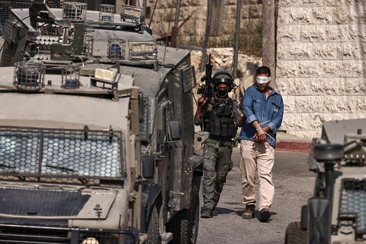 Soldados israelíes detienen a un palestino en Ramallah.