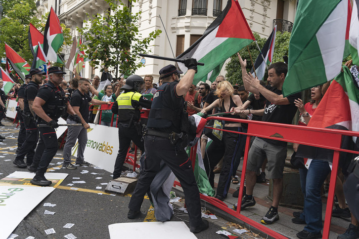 Un ertzaina arremete contra el público en la zona de la meta de la etapa de la Vuelta en Bilbo.