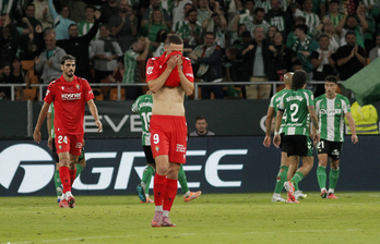 Raúl, que no ha tenido gran incidencia, se tapa la cara con la camiseta, con Catena al fondo, cuyo grave error supuso el 1-0.